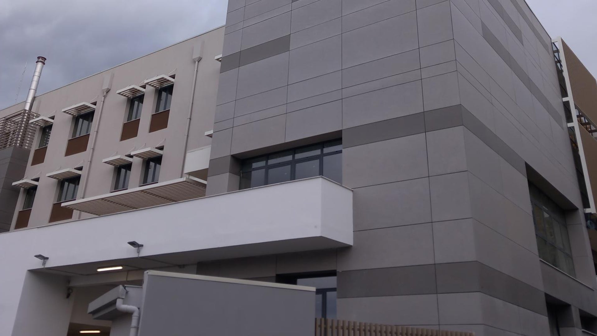 Modern gray building under cloudy sky