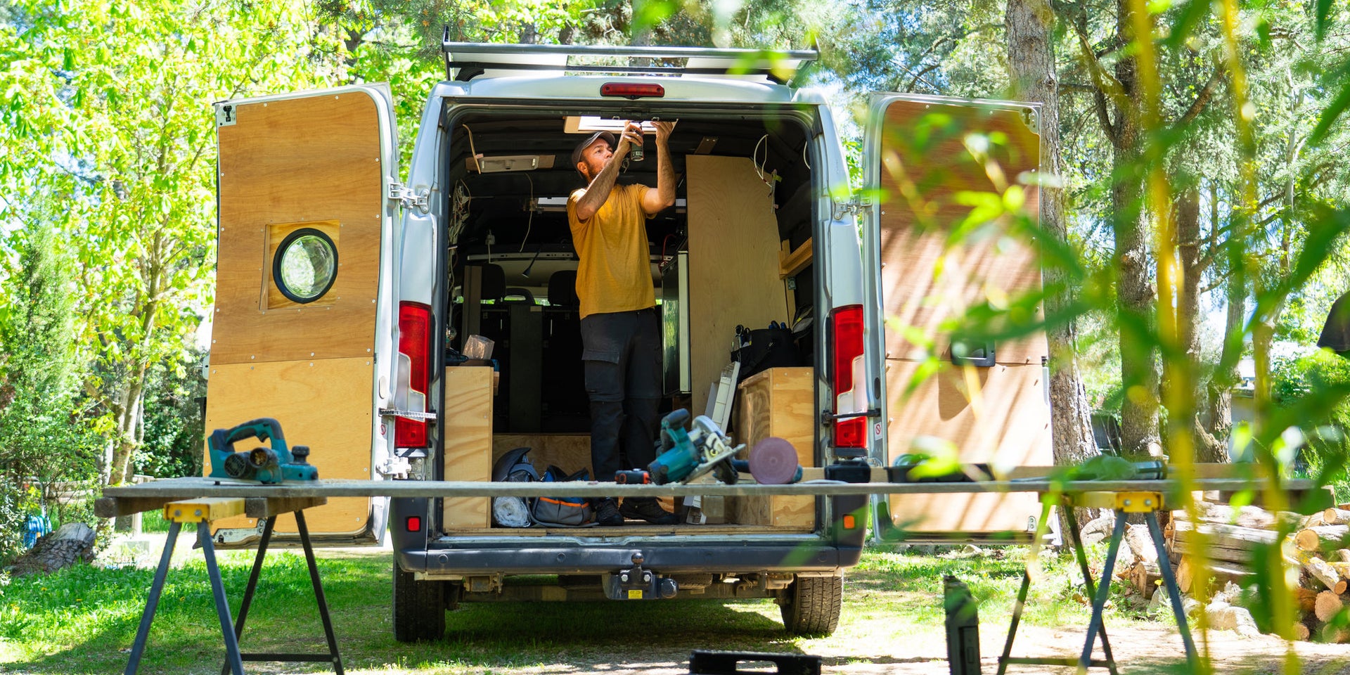 Carpenter working inside open van outdoors