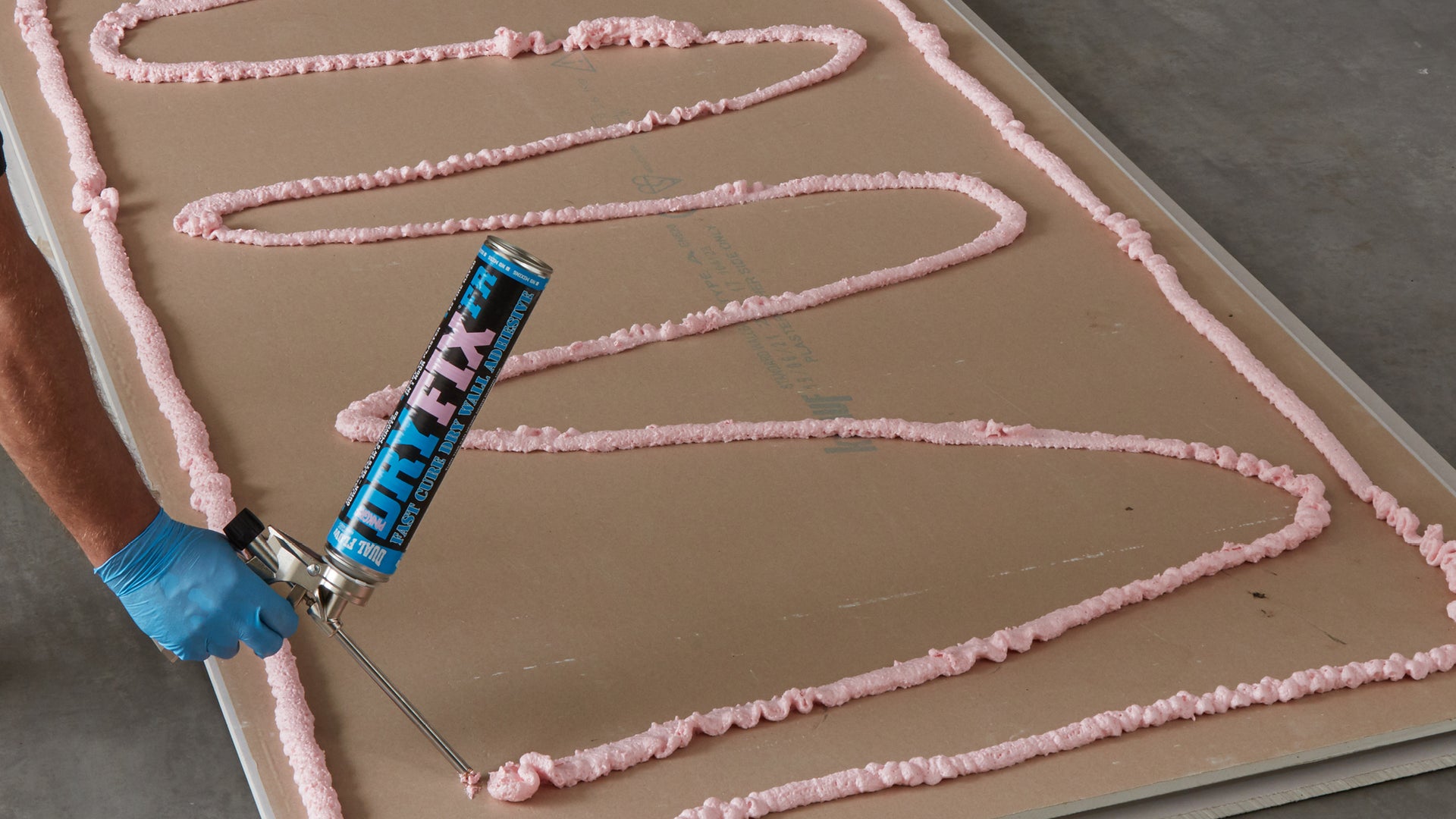 Person applying Dryfix adhesive to plasterboard