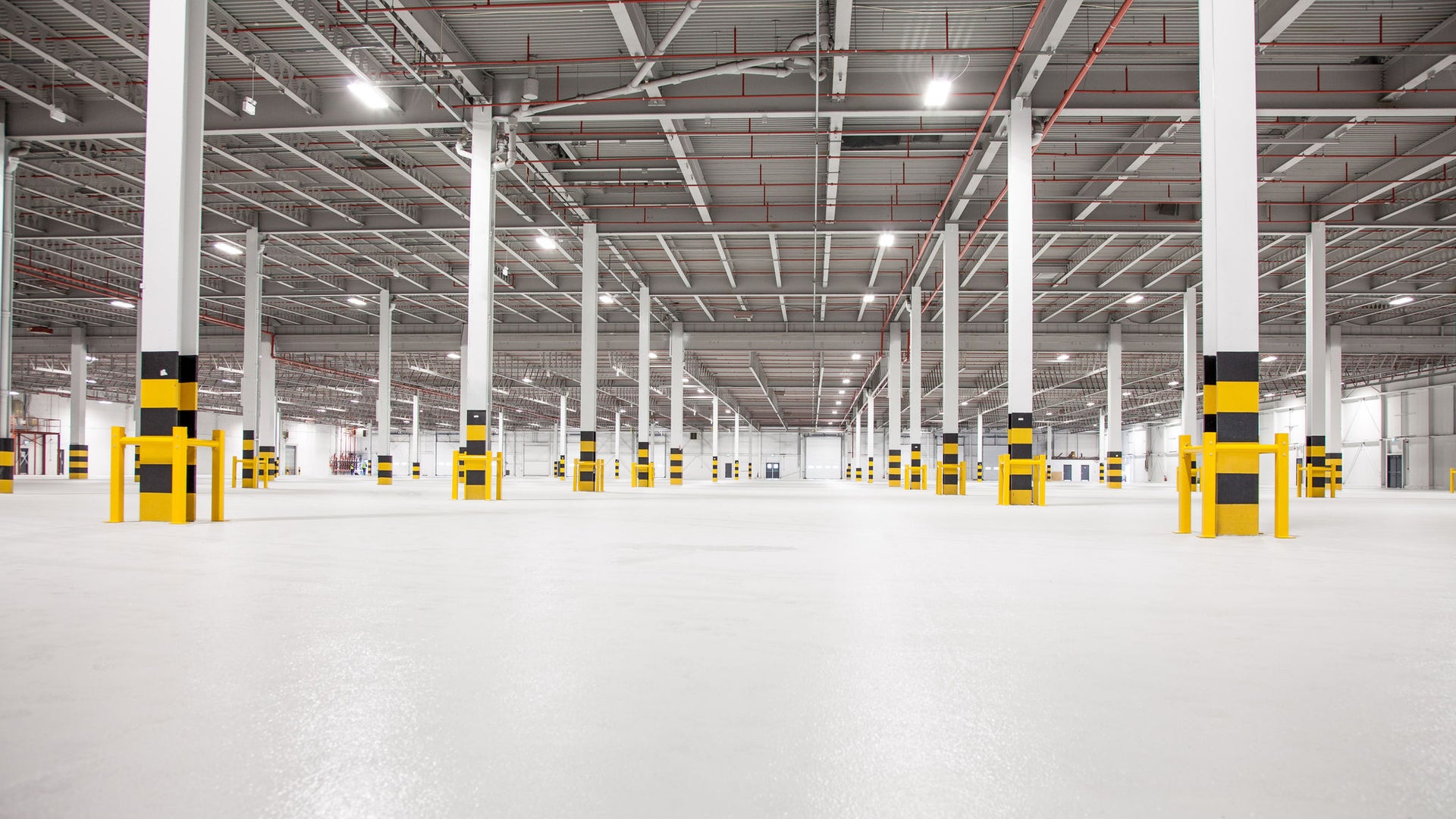 Photo of a newly constructed, empty warehouse with focus on the concrete floor