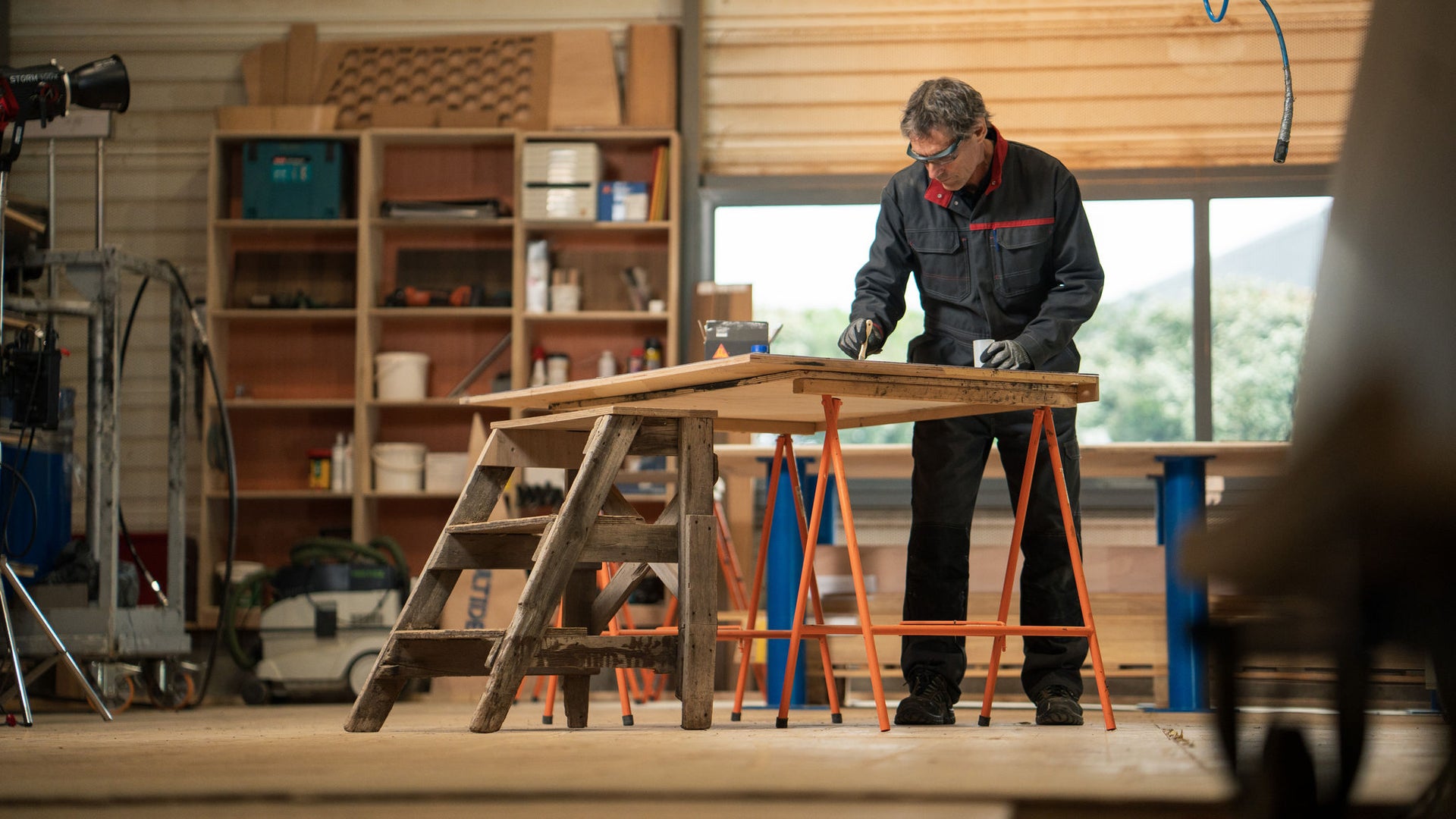 Carpenter sanding wooden board in workshop