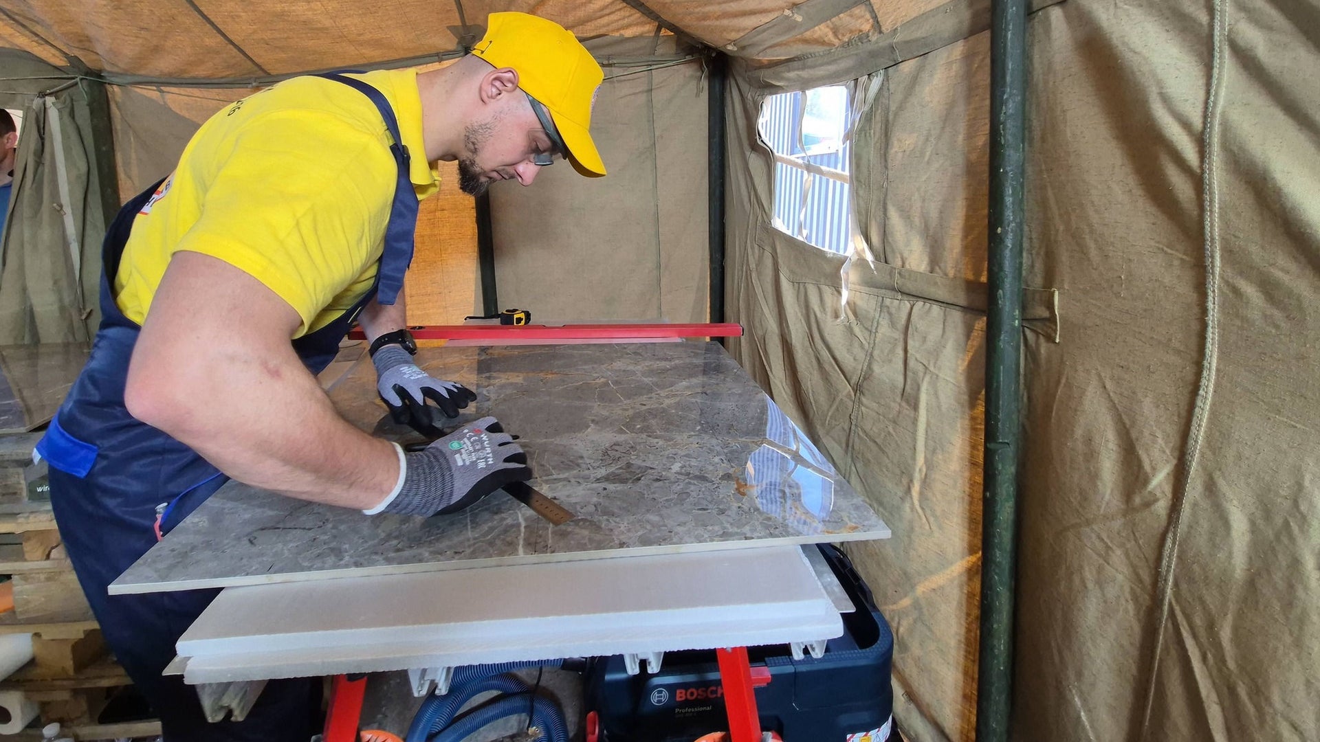 Construction worker cutting large ceramic tile