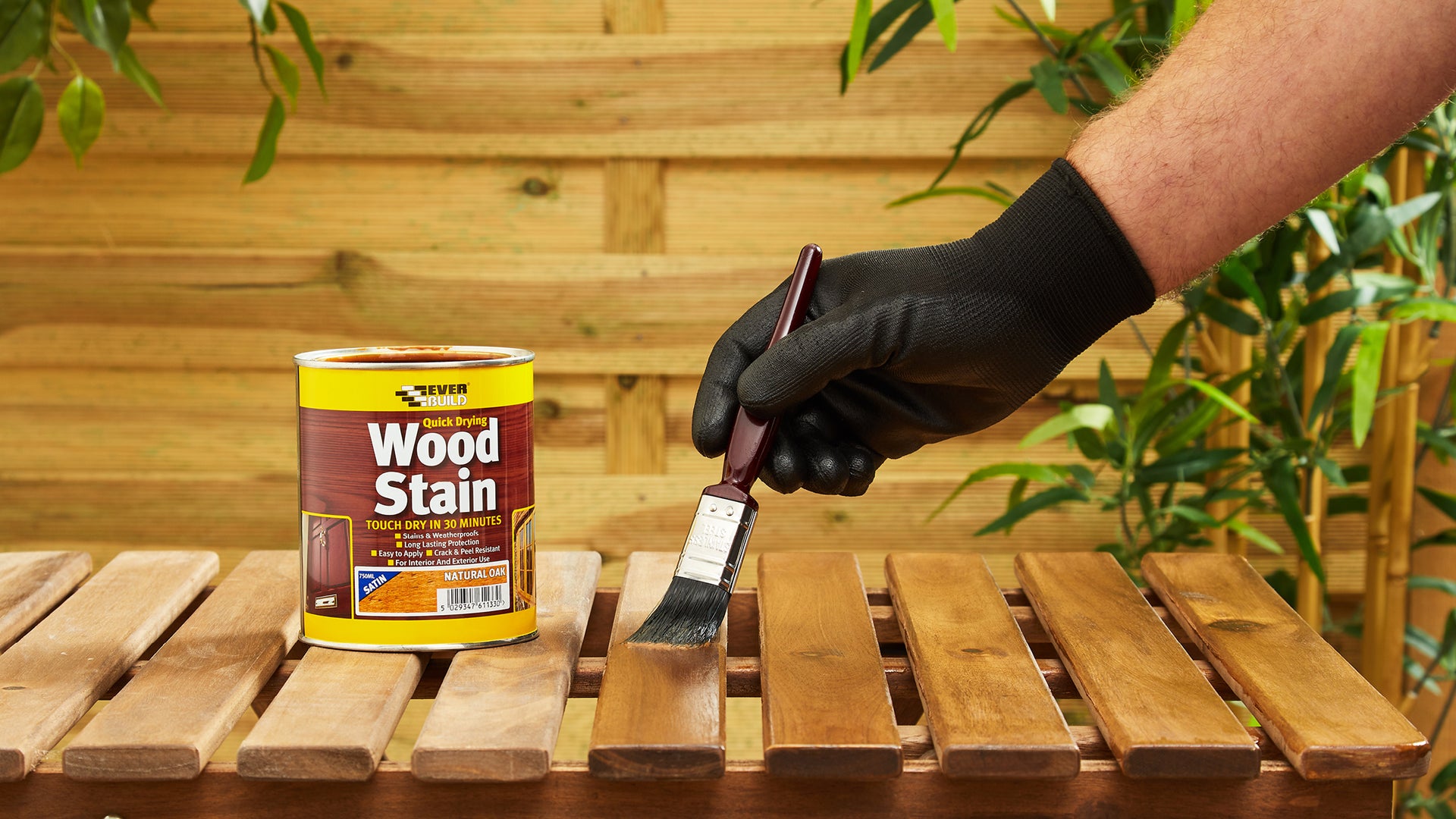 Person applying wood stain to wooden table