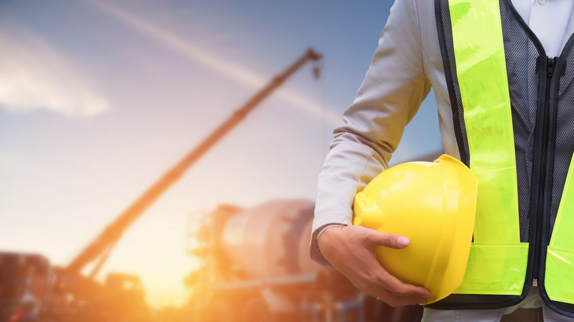Construction worker holding yellow safety helmet