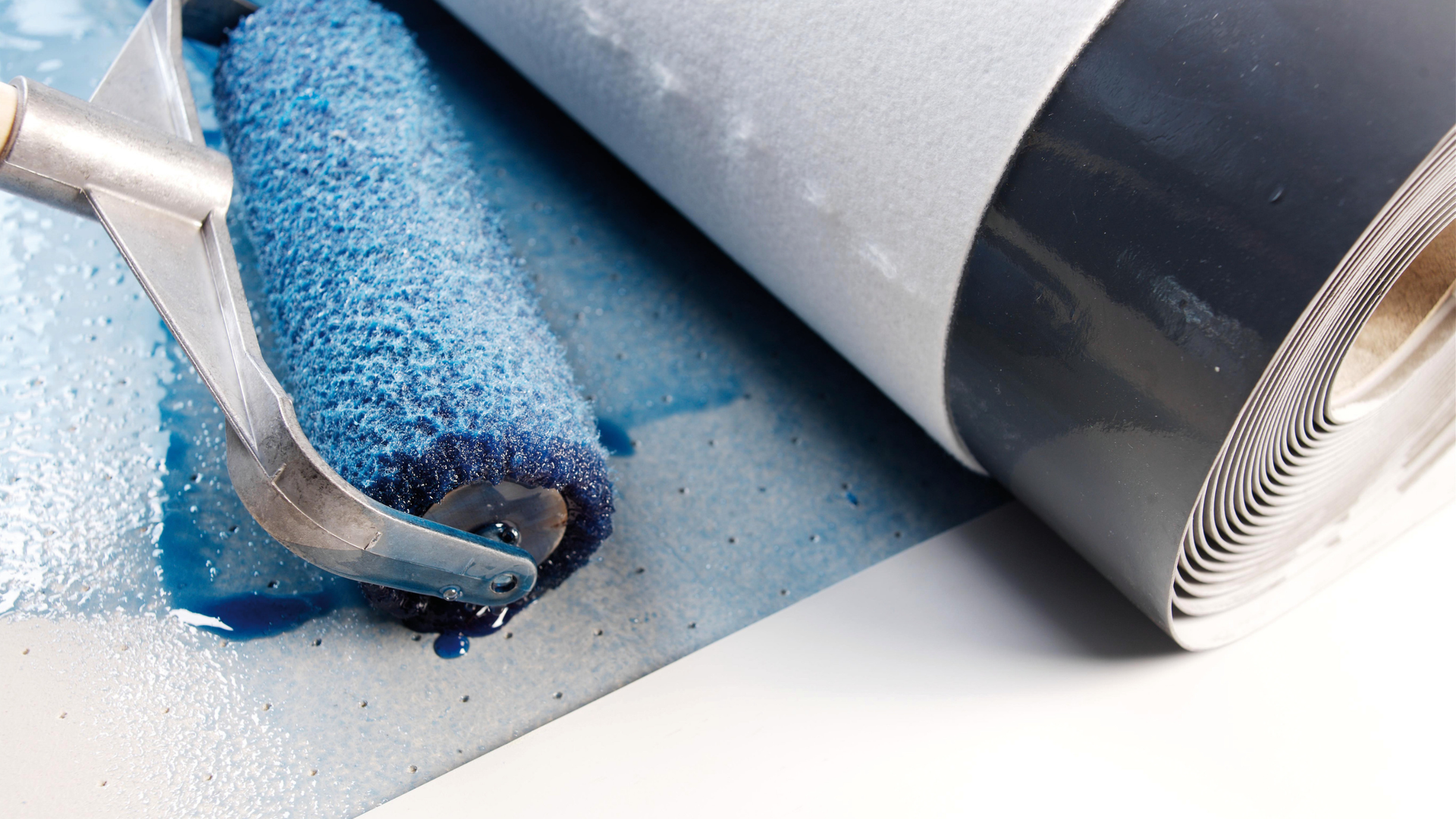 Paint roller applying blue coating on surface