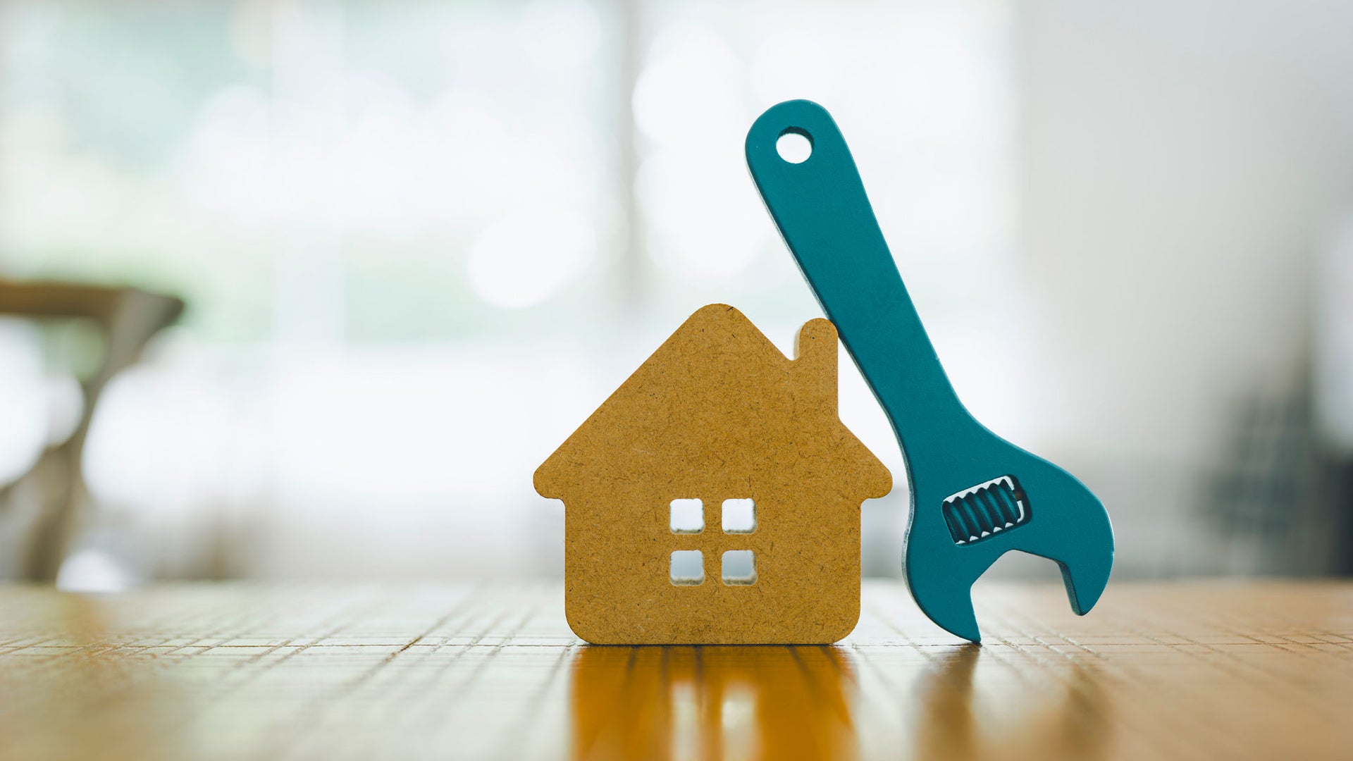 Wooden House Model with Blue Wrench Indoors