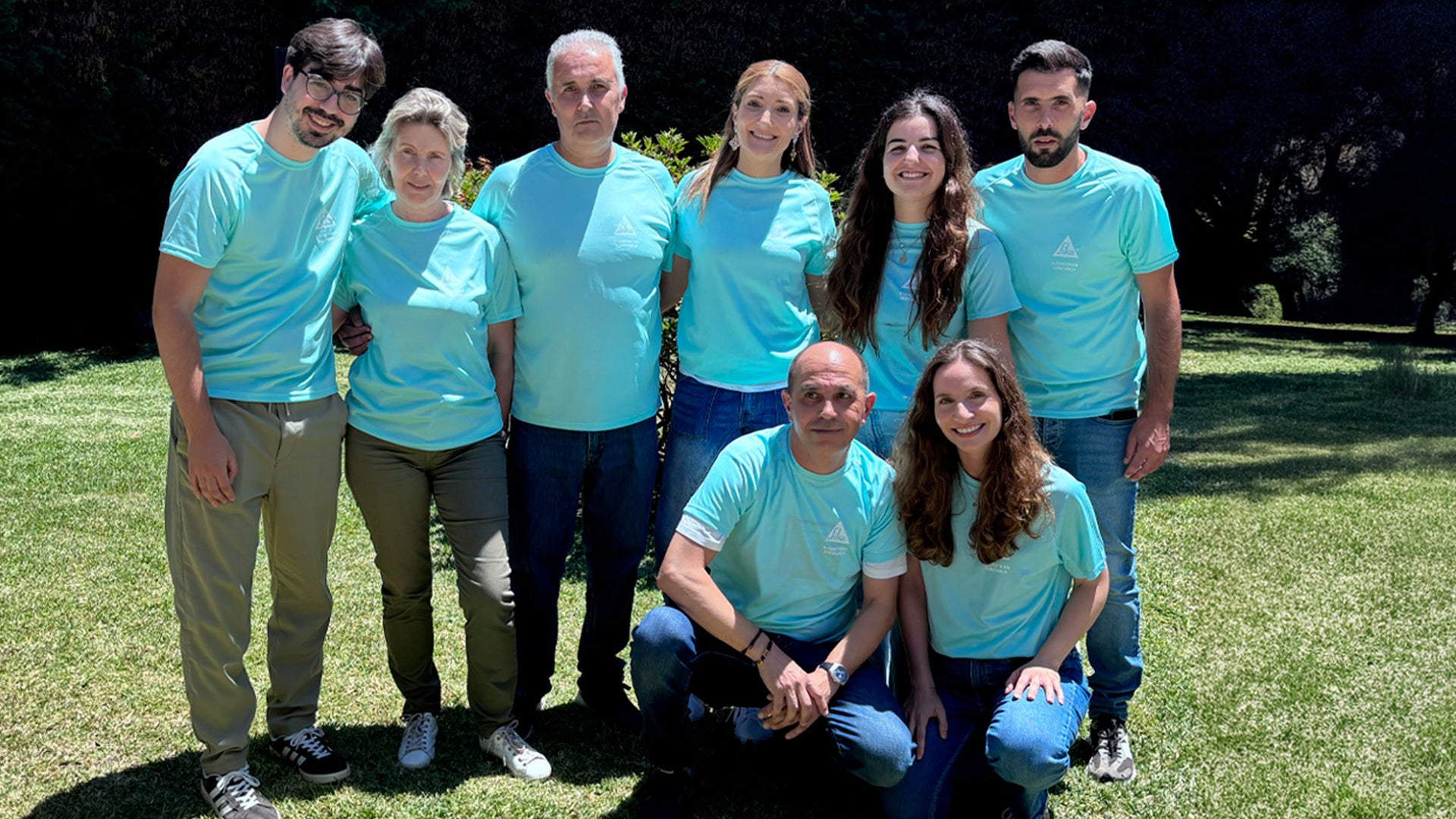 Multigenerational group in matching turquoise shirts