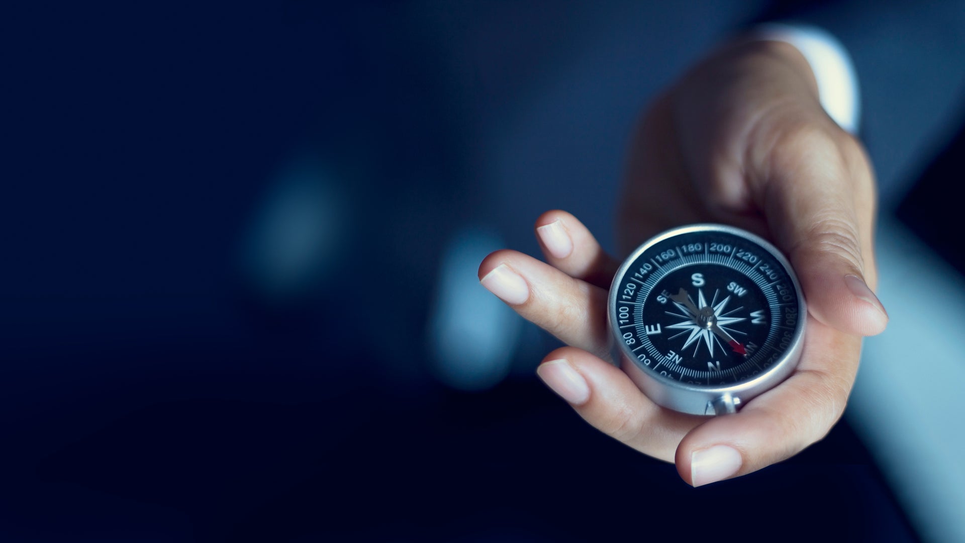 Businessperson holding compass for direction