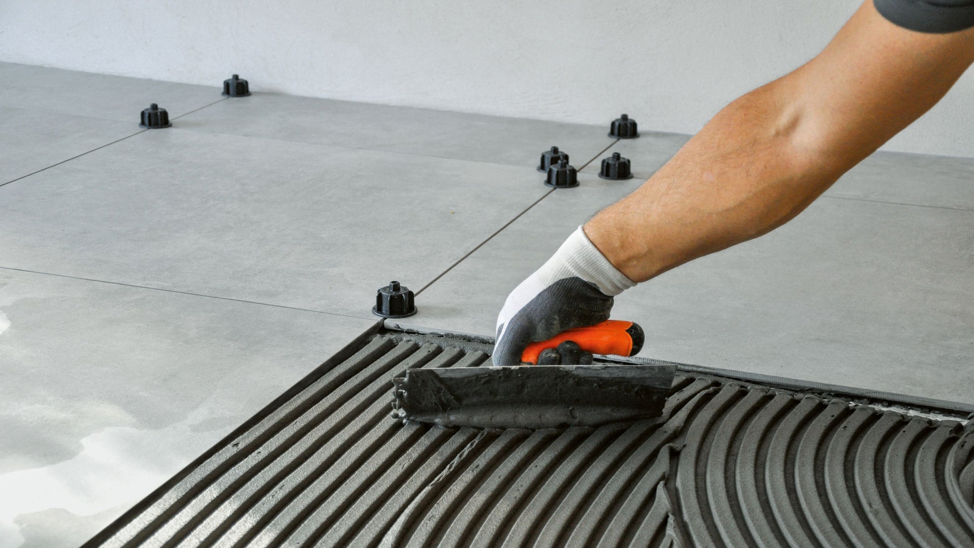 hand trowel application of leveling compound tile adhesive