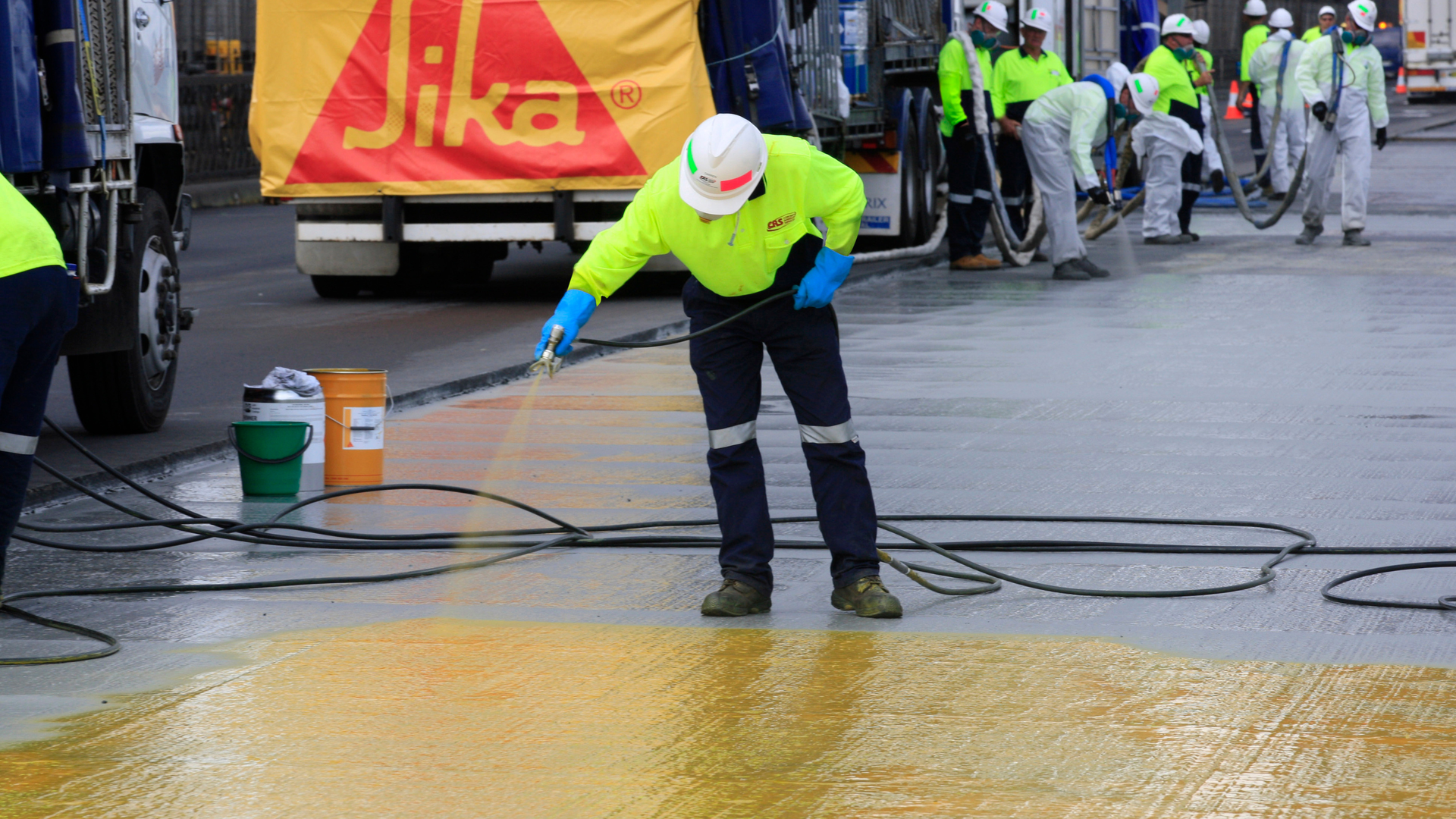 man applying waterproof coating to bridge deck