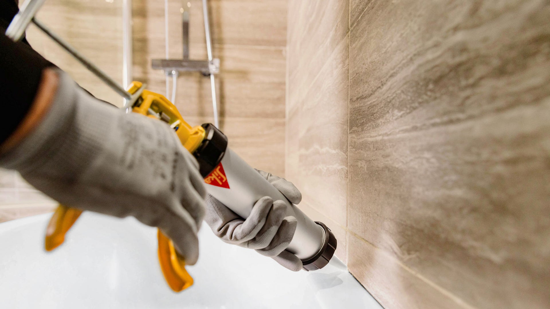 Applying Sealant to Bathtub Edge with Caulking Gun