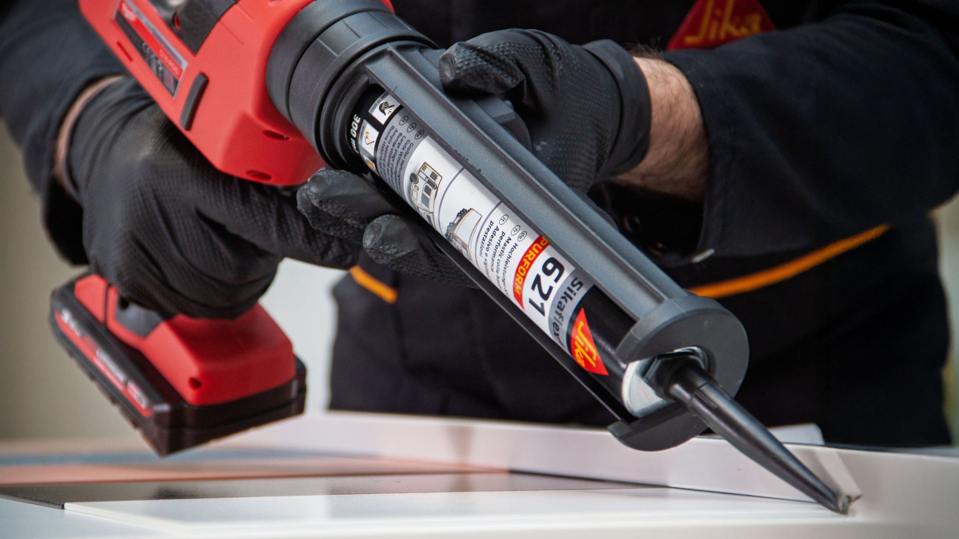 Handheld caulking gun in use indoors