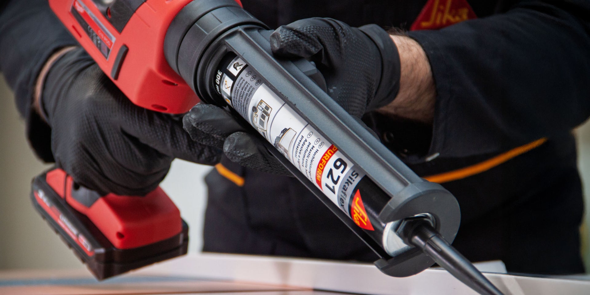Handheld caulking gun in use indoors