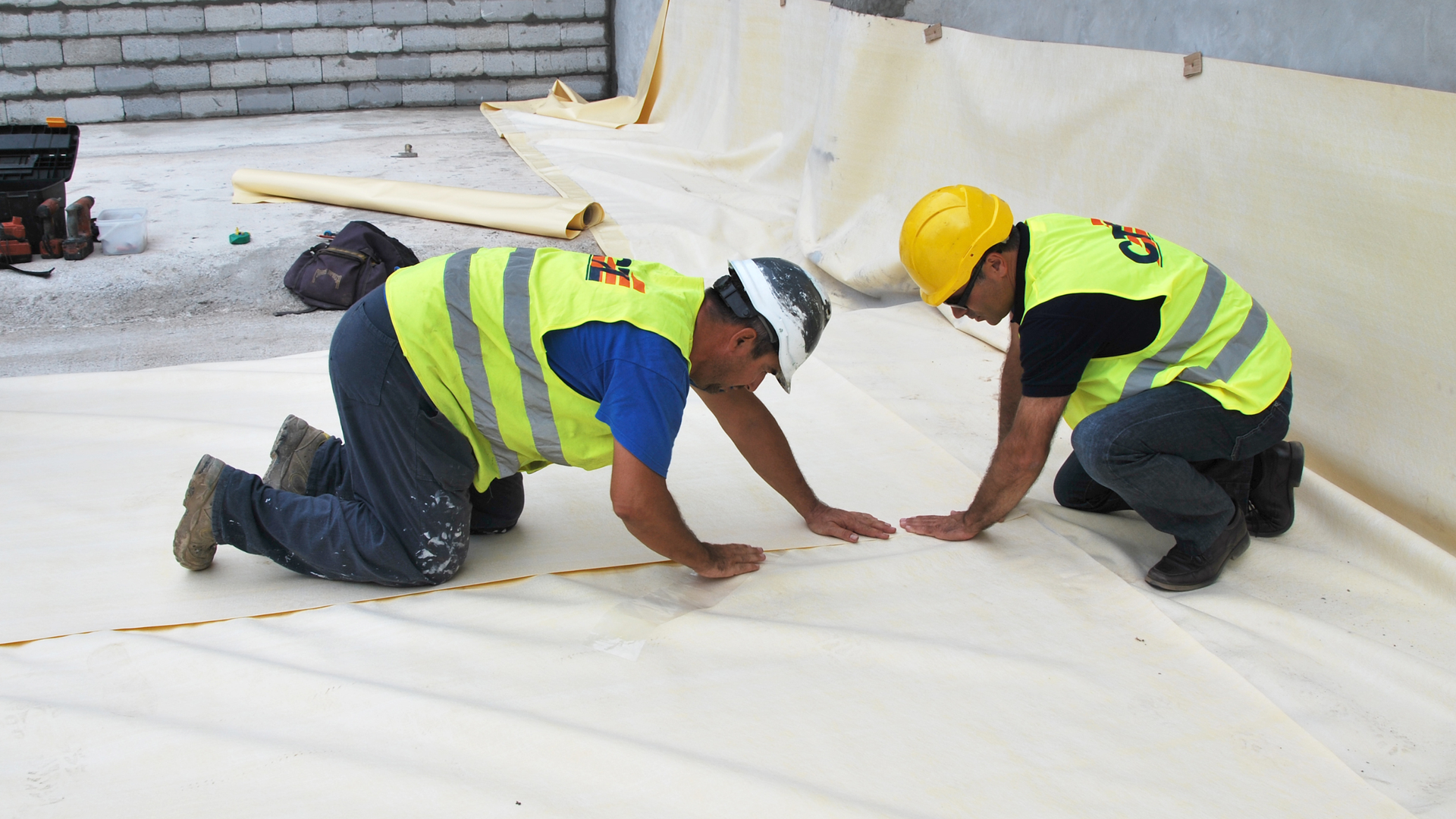 construction workers applying waterproof sheet membrane
