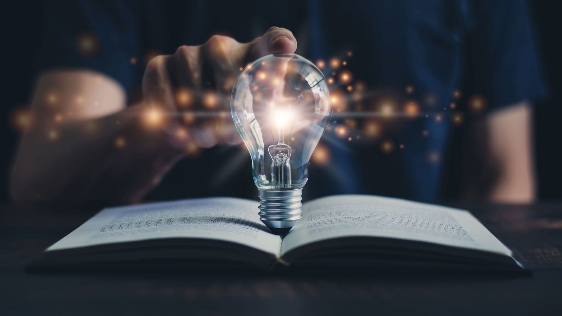 Animated lightbulb over a book with male touching the glass
