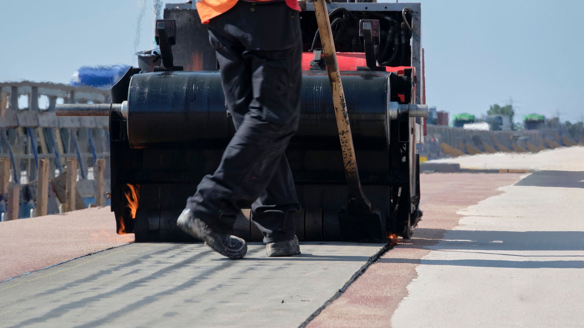 Construction worker operating asphalt paving machine