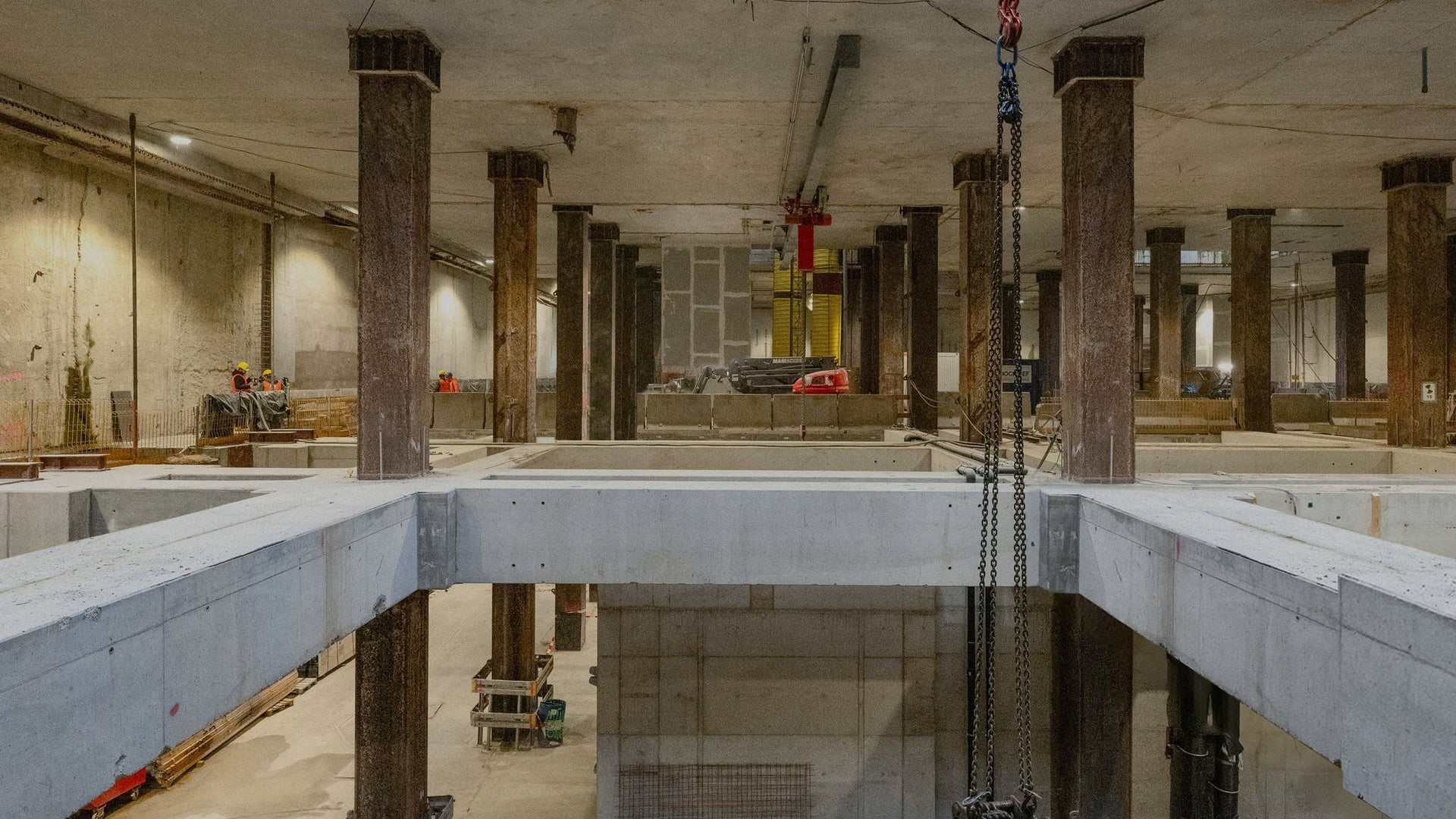 Large indoor construction site with concrete pillars and beams