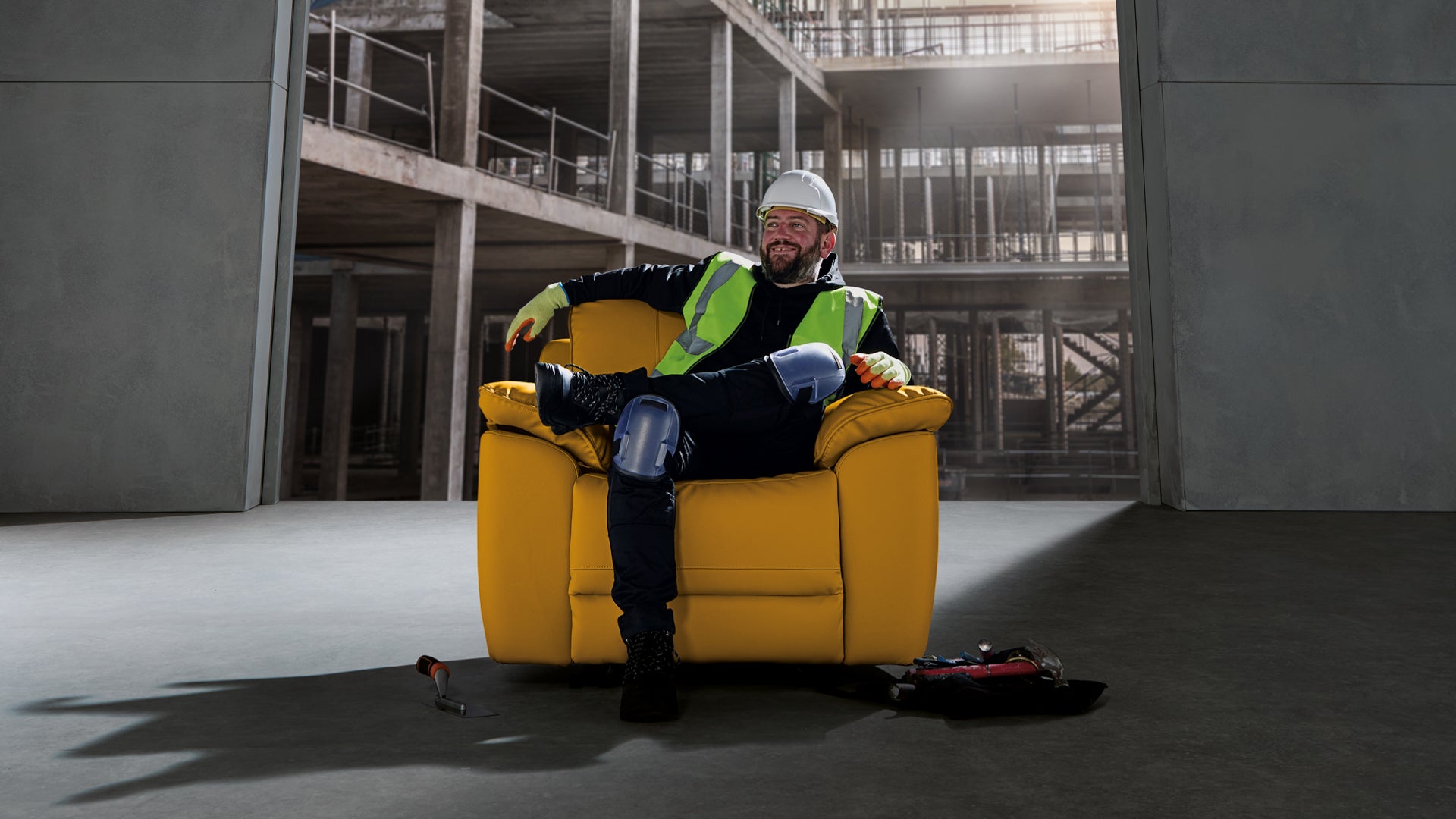 Construction worker relaxing on yellow armchair indoors