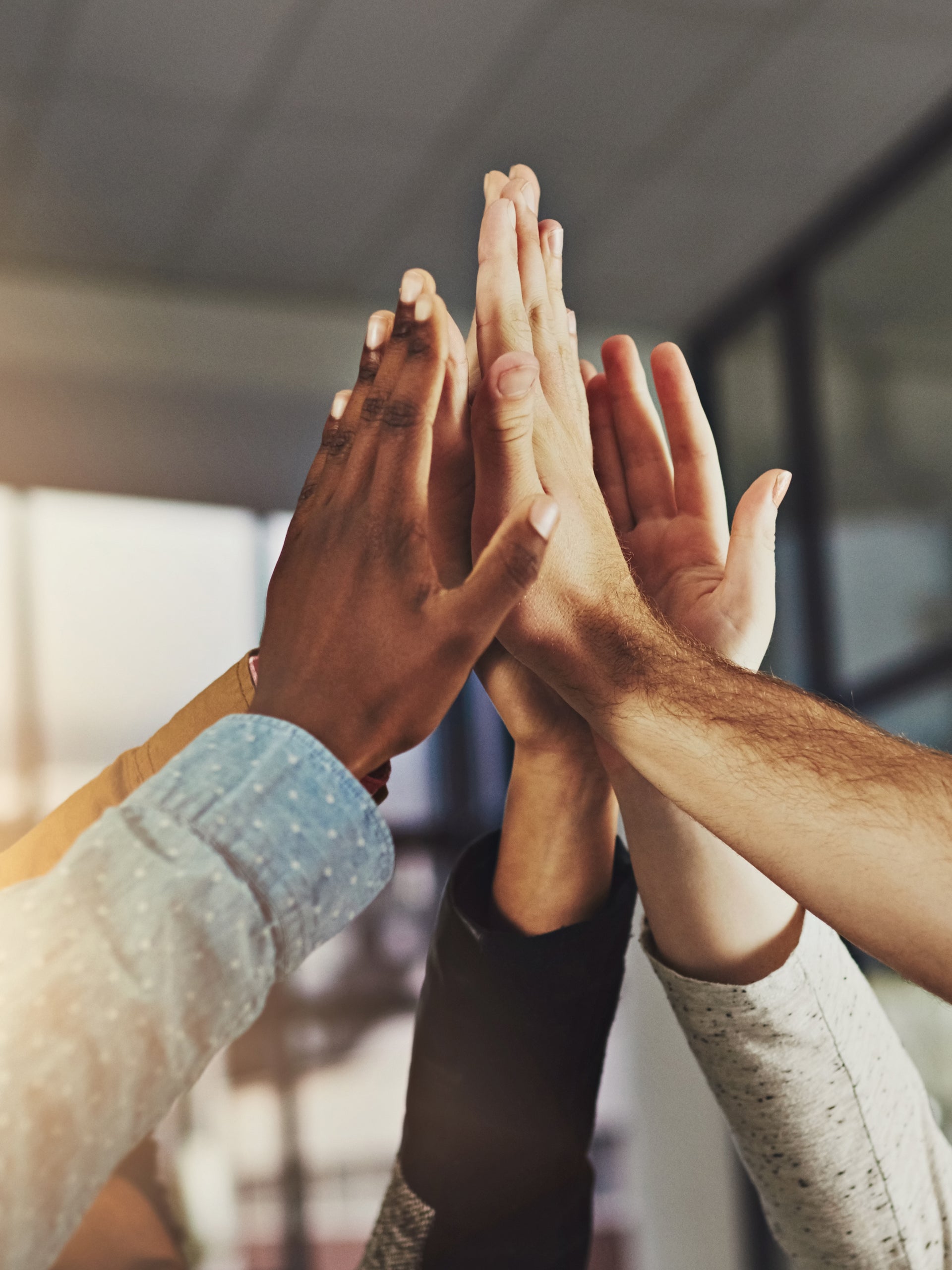 Diverse team joining hands in high five