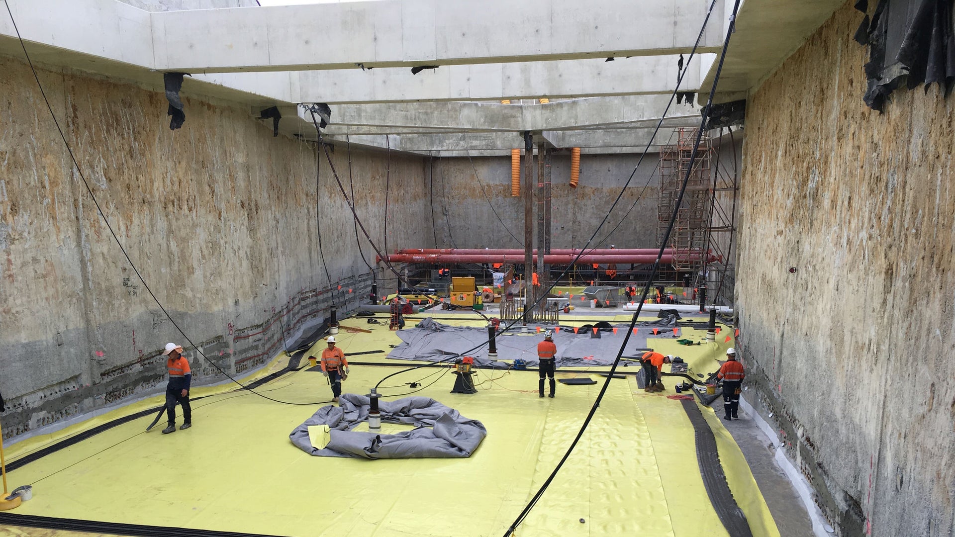 men applying waterproofing membranes to basement