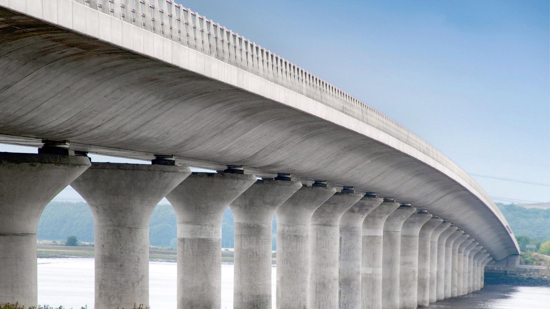 Modern concrete bridge spanning wide river landscape