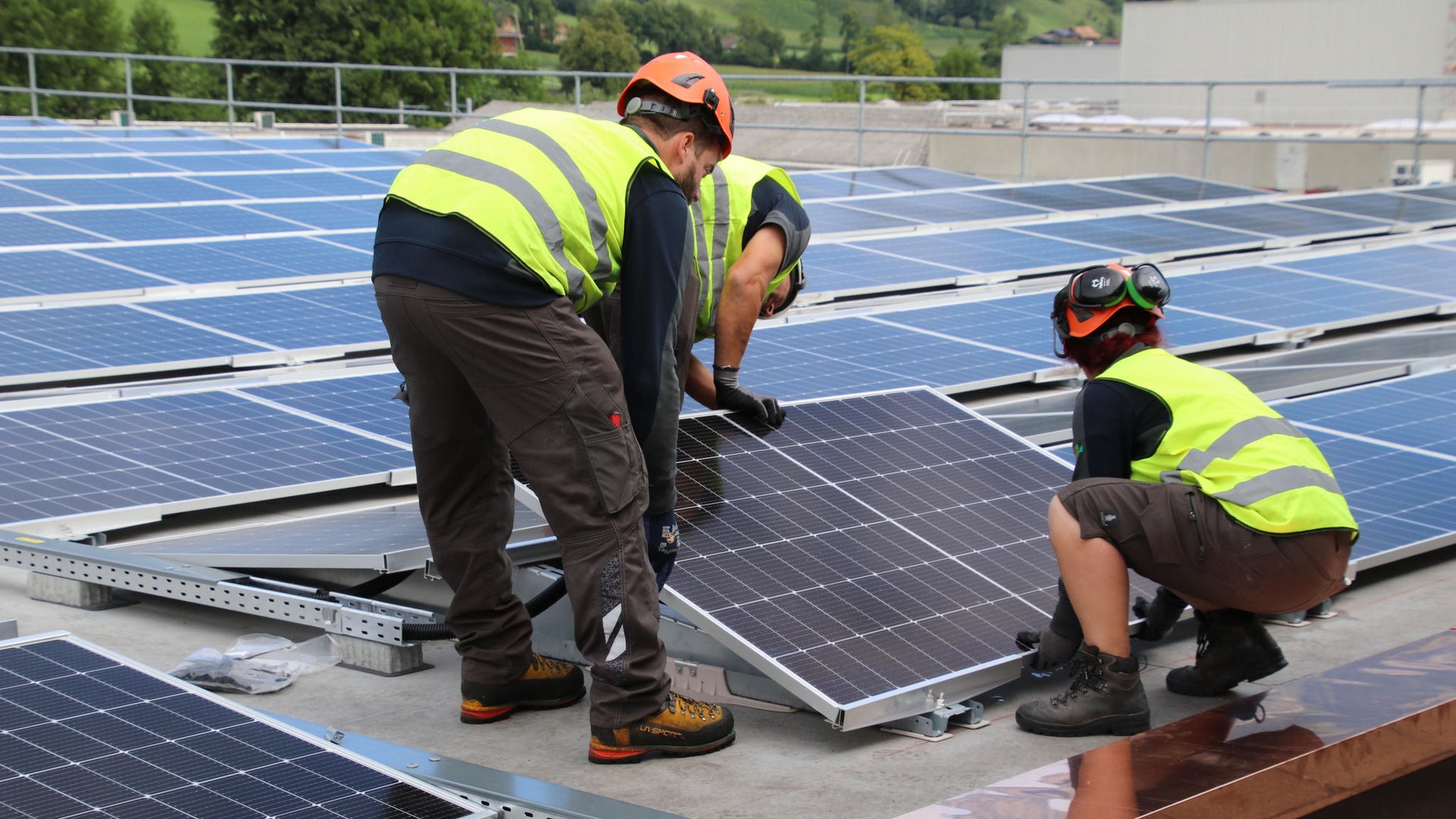 Workers installing solar panels on rooftop