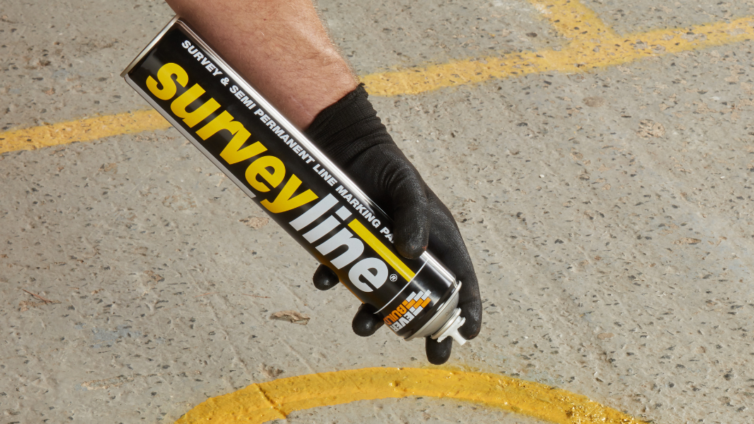 Hand using Surveyline spray on pavement