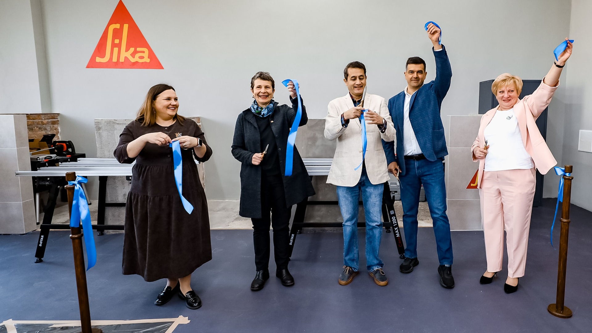 Group ribbon cutting ceremony at indoor event