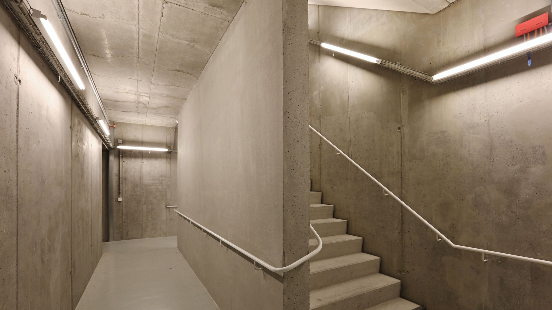 Concrete stairwell with lights in basement parking garage