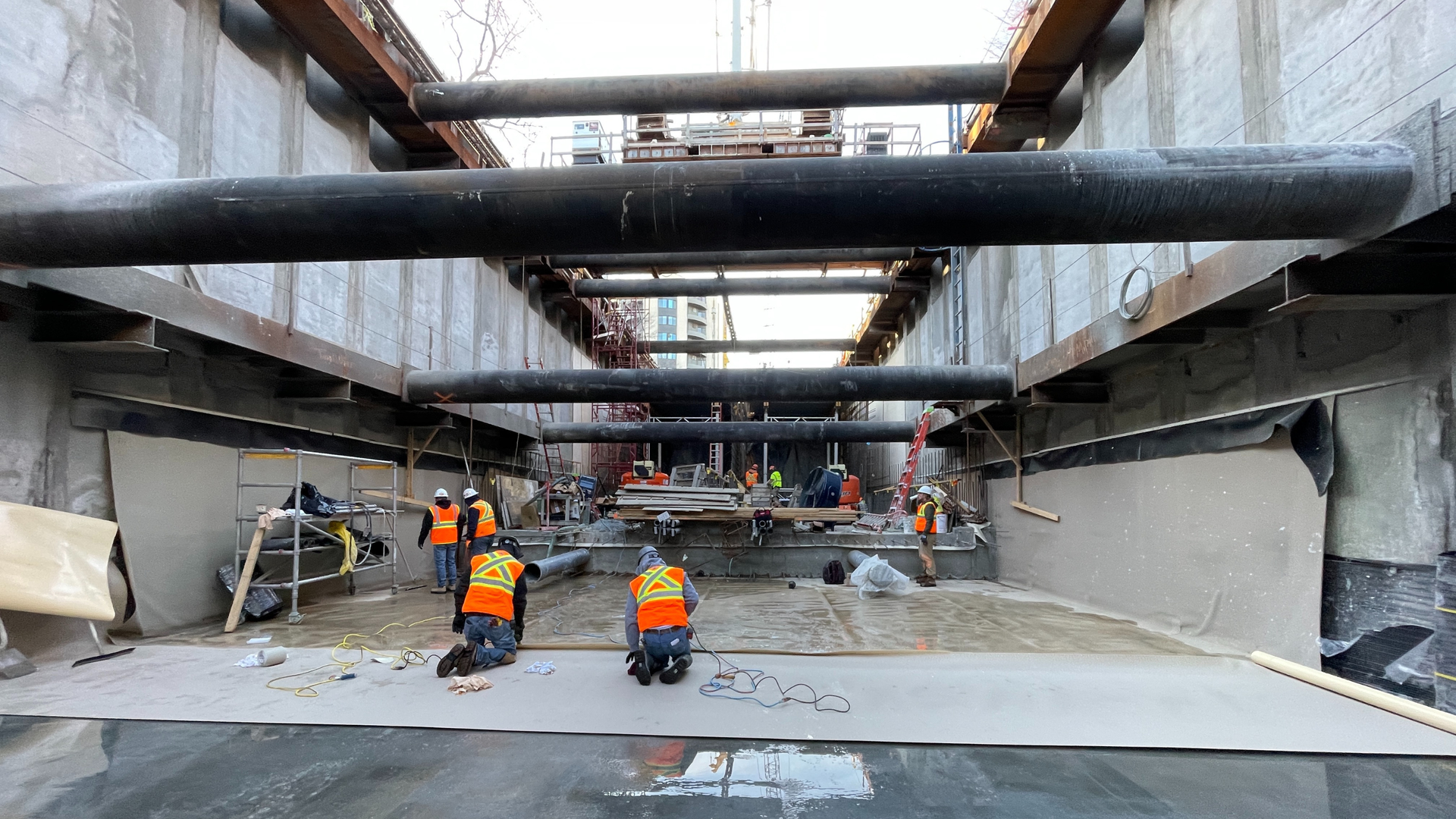 construction workers waterproofing basement