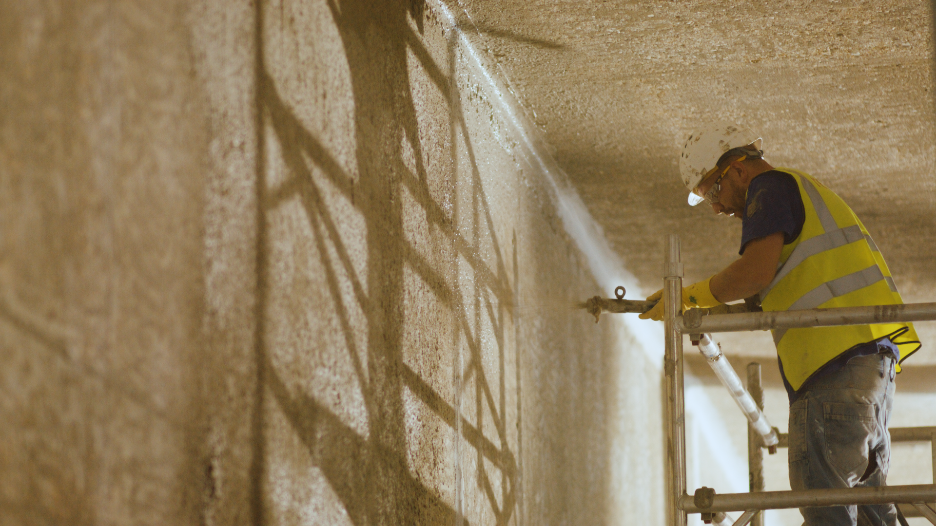 Construction worker painting concrete wall