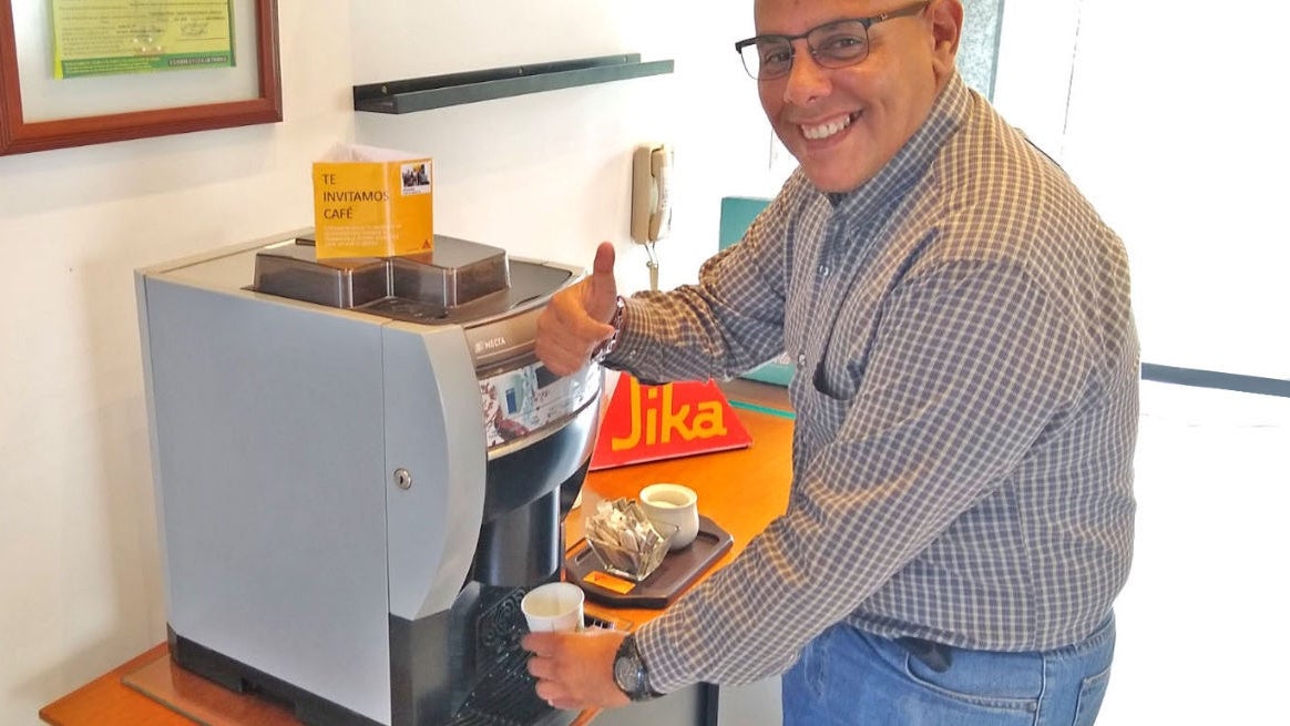 Man preparing coffee at office machine station
