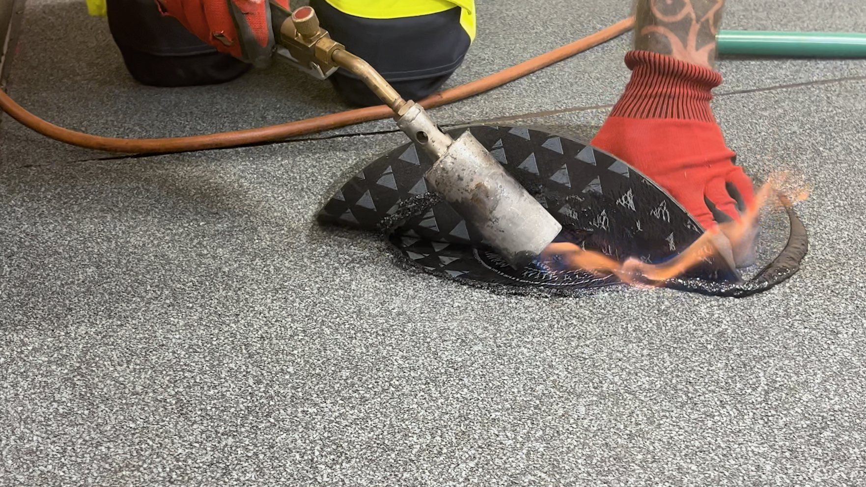 Worker heat welding textured flooring sheet