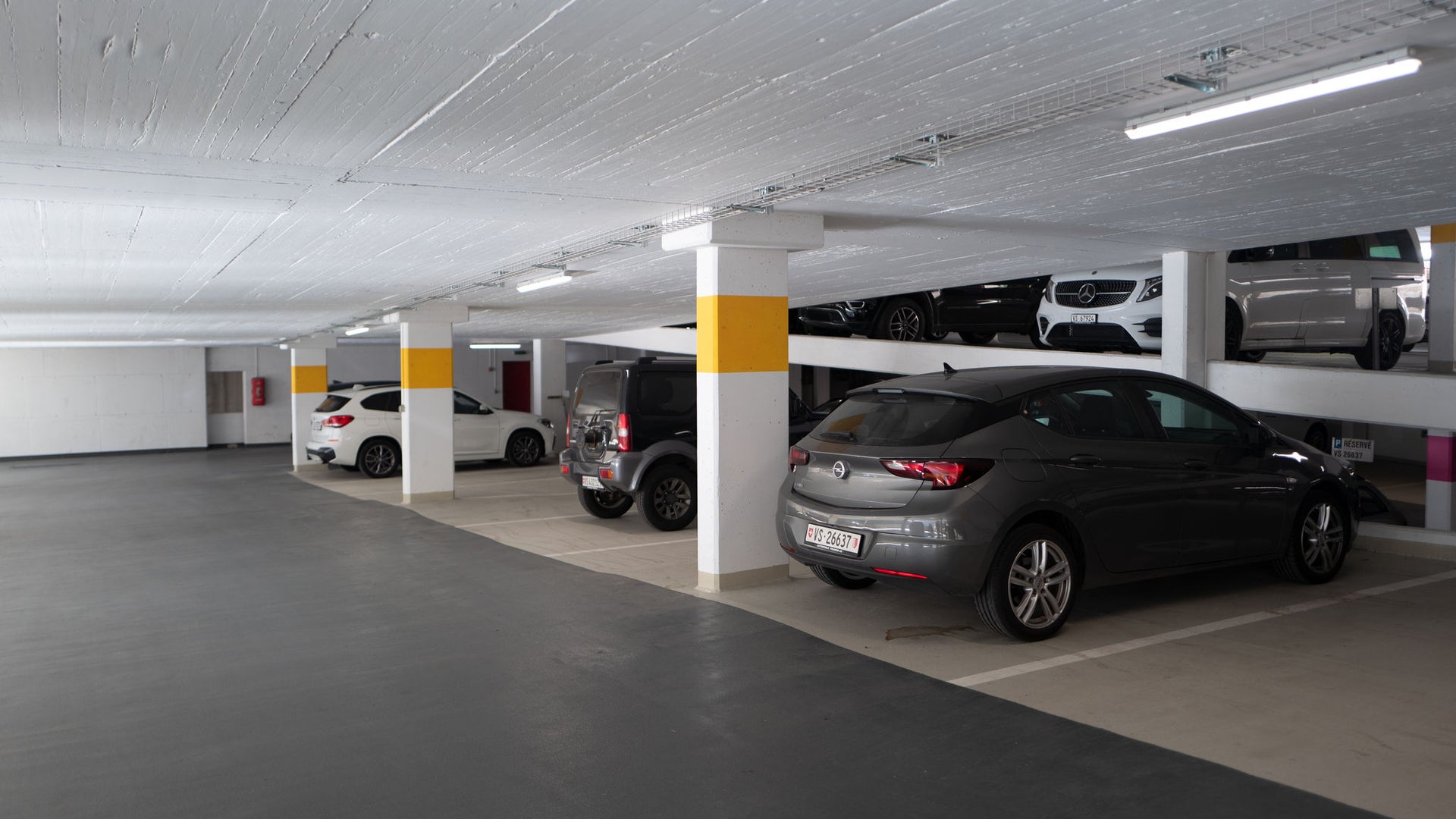 Saas Fee parking garage with concrete ceiling and cars parked