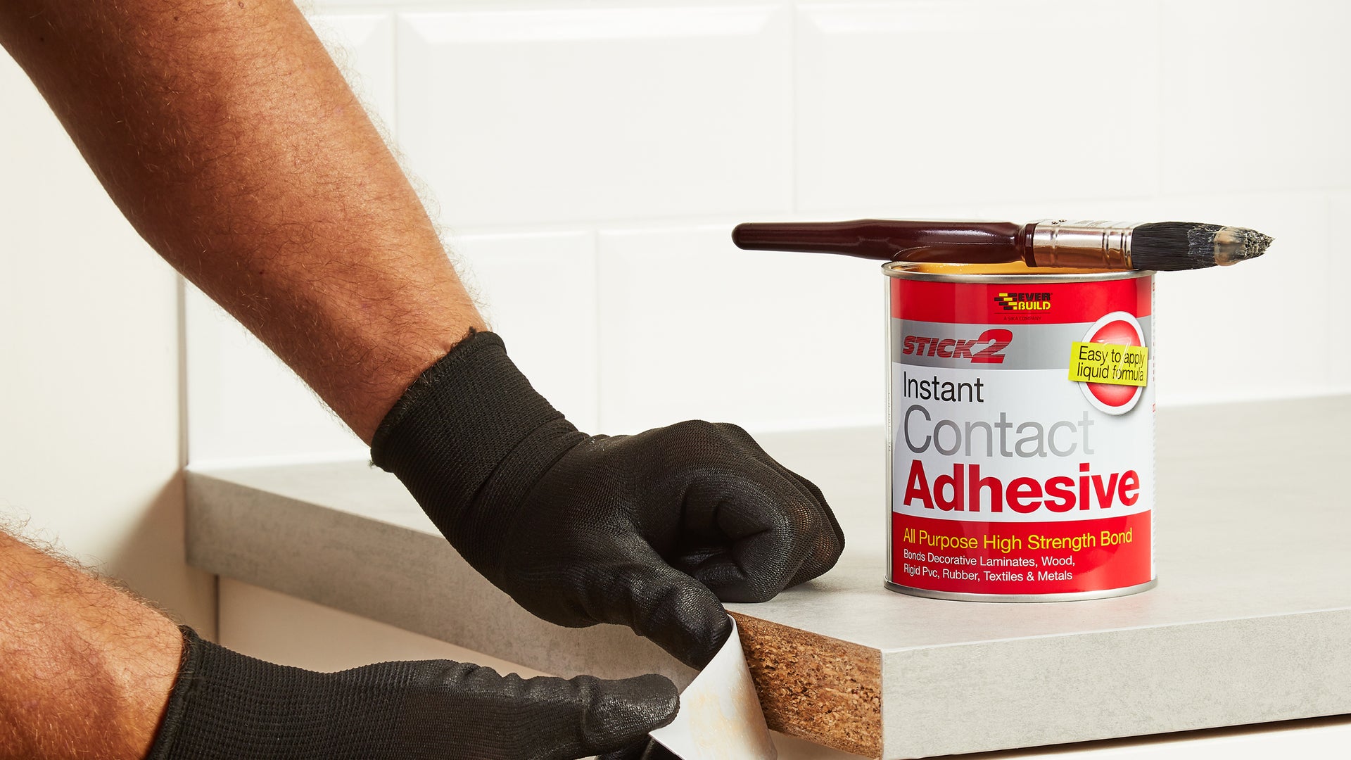 Person applying Instanf Contact Adhesive to worktop