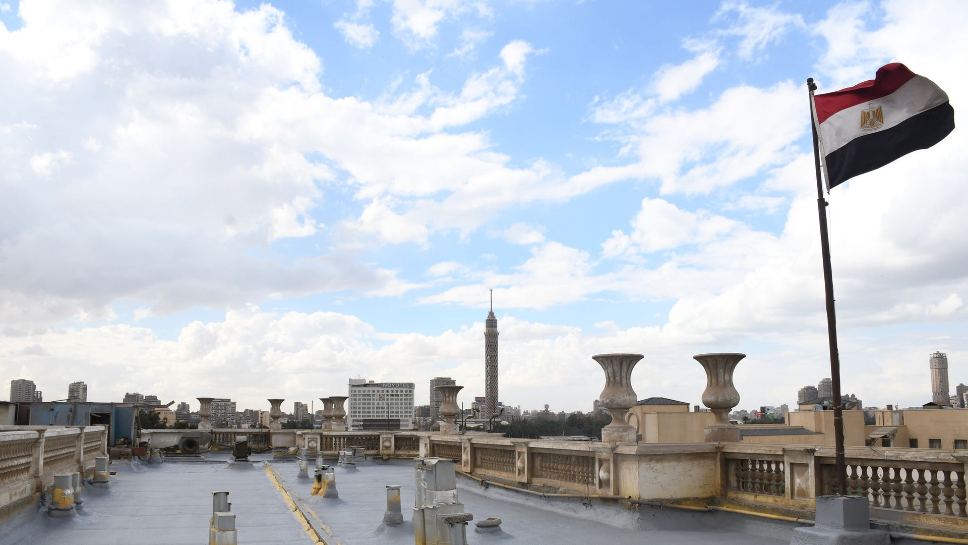 Egyptian Flag on Rooftop Overlooking City Skyline