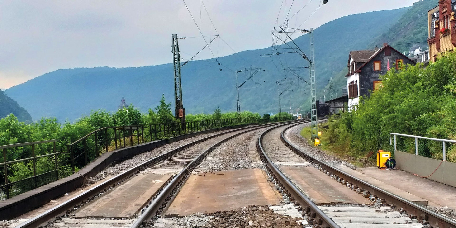 Curving railway tracks through green mountain valley
