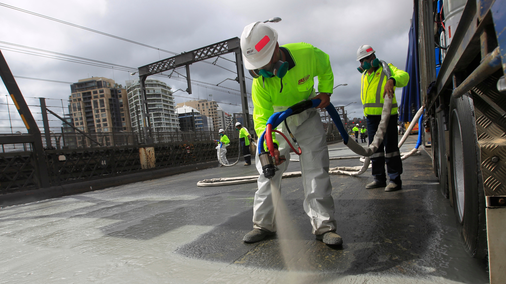 men spraying liquid applied waterproofing membrane