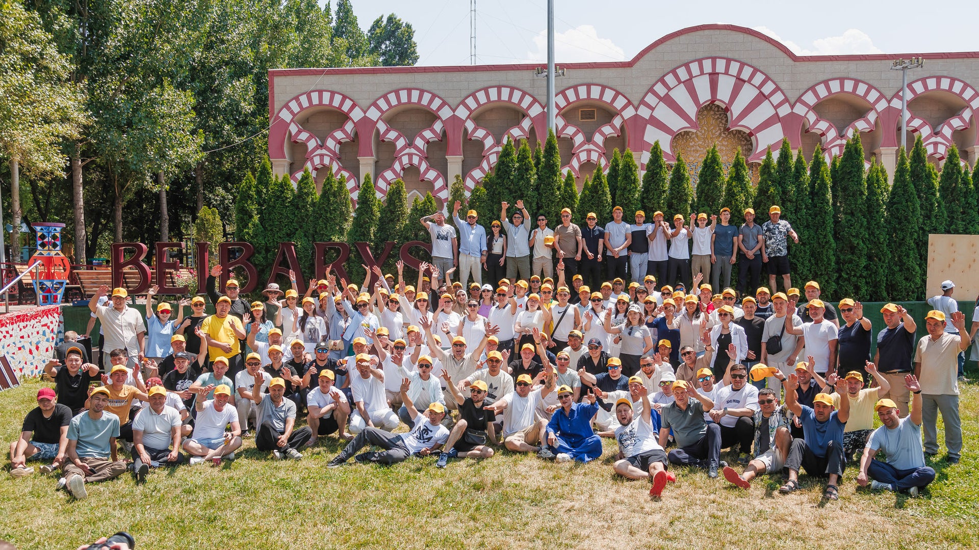 Large group photo outdoors in front of decorative building