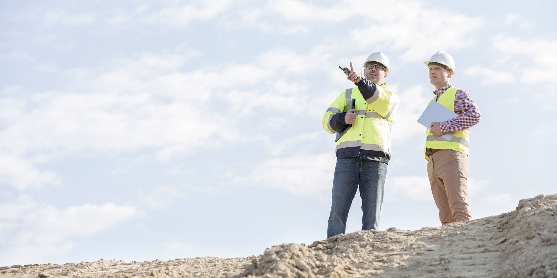 Construction engineers surveying work site outdoors
