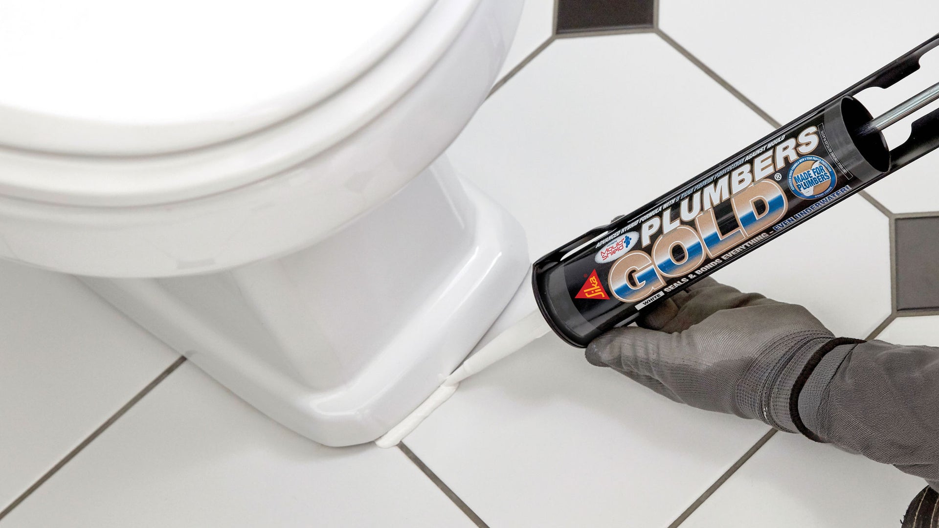 Man applying sealant around toiler