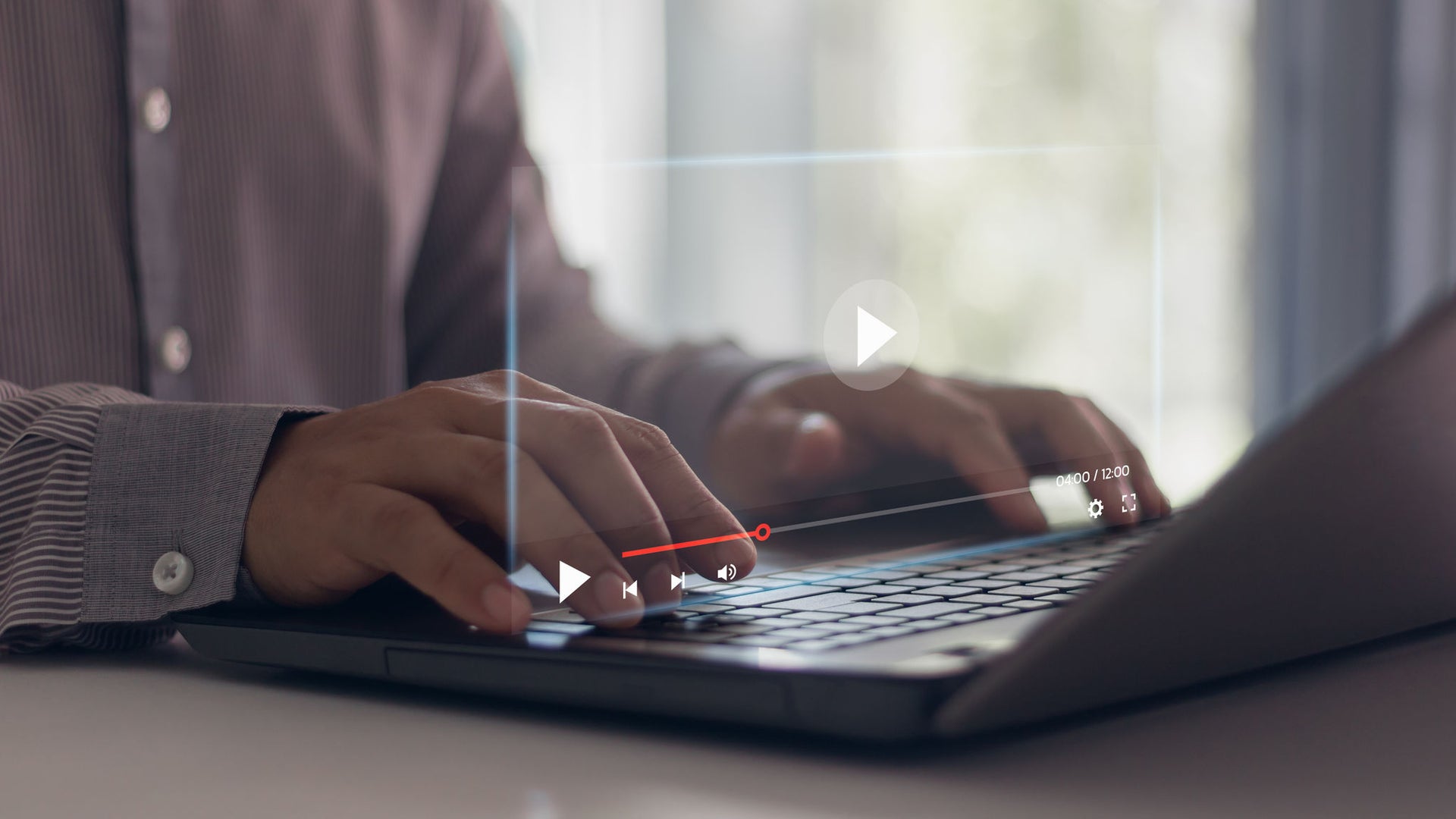 Person typing on laptop with video overlay
