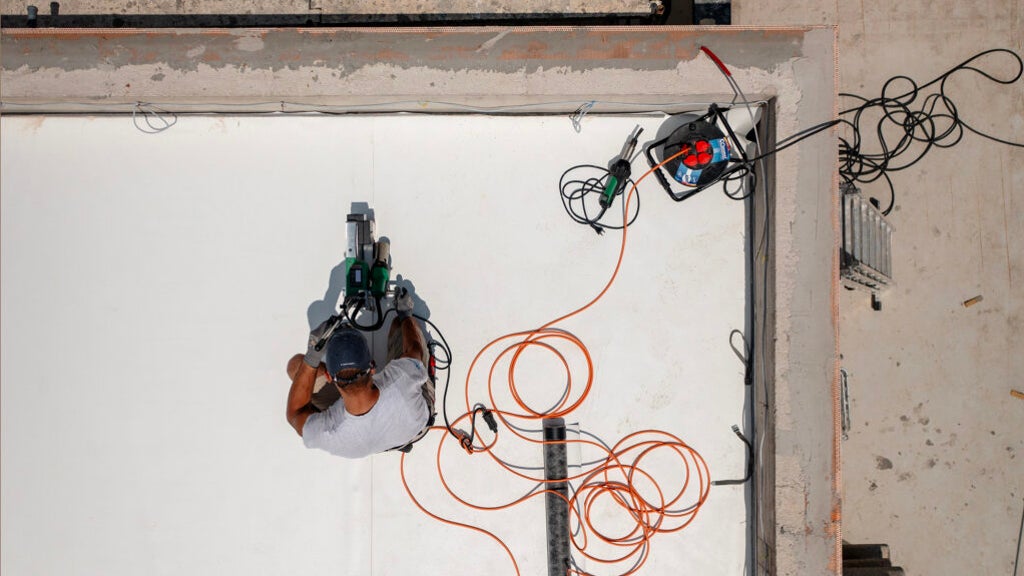 Worker using power tool on construction site